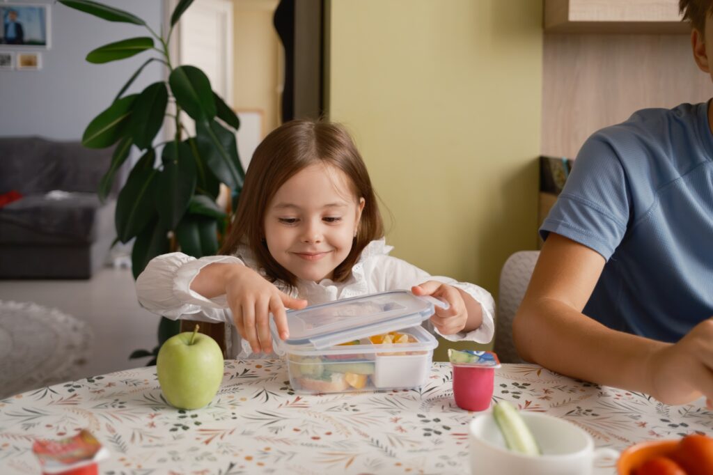 Young girl packing a healthy lunch box for school