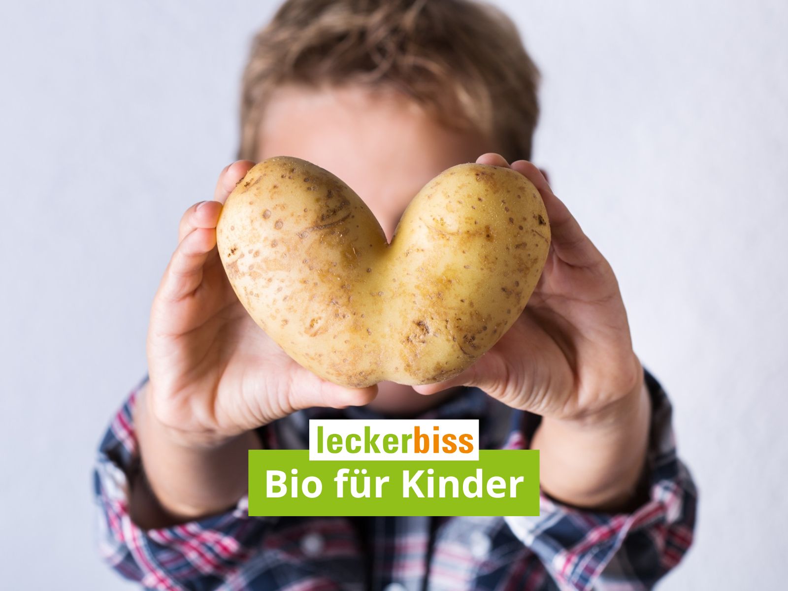 Kind hält herzförmige Kartoffel – Symbol für Bio-Liebe bei leckerbiss