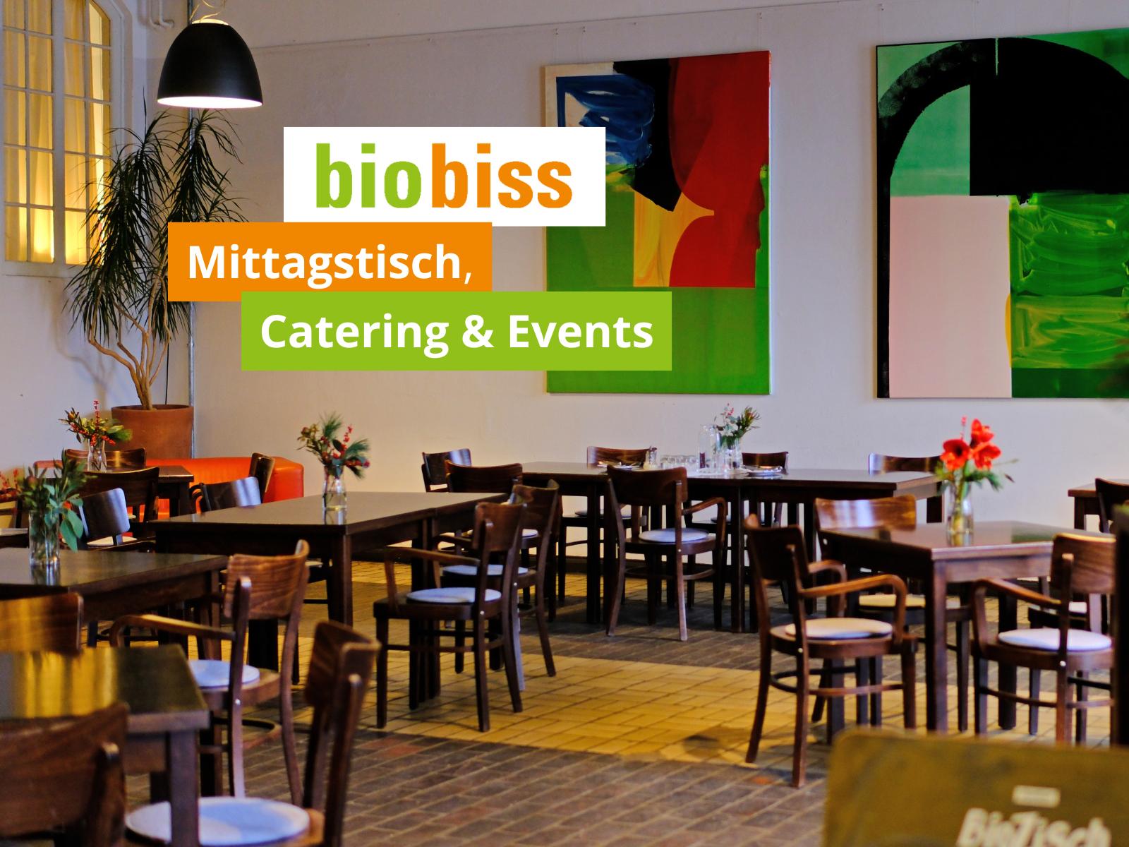 Moderner Speisesaal mit Holztischen und Kunst an der Wand – biobiss Mittagstisch & Events
